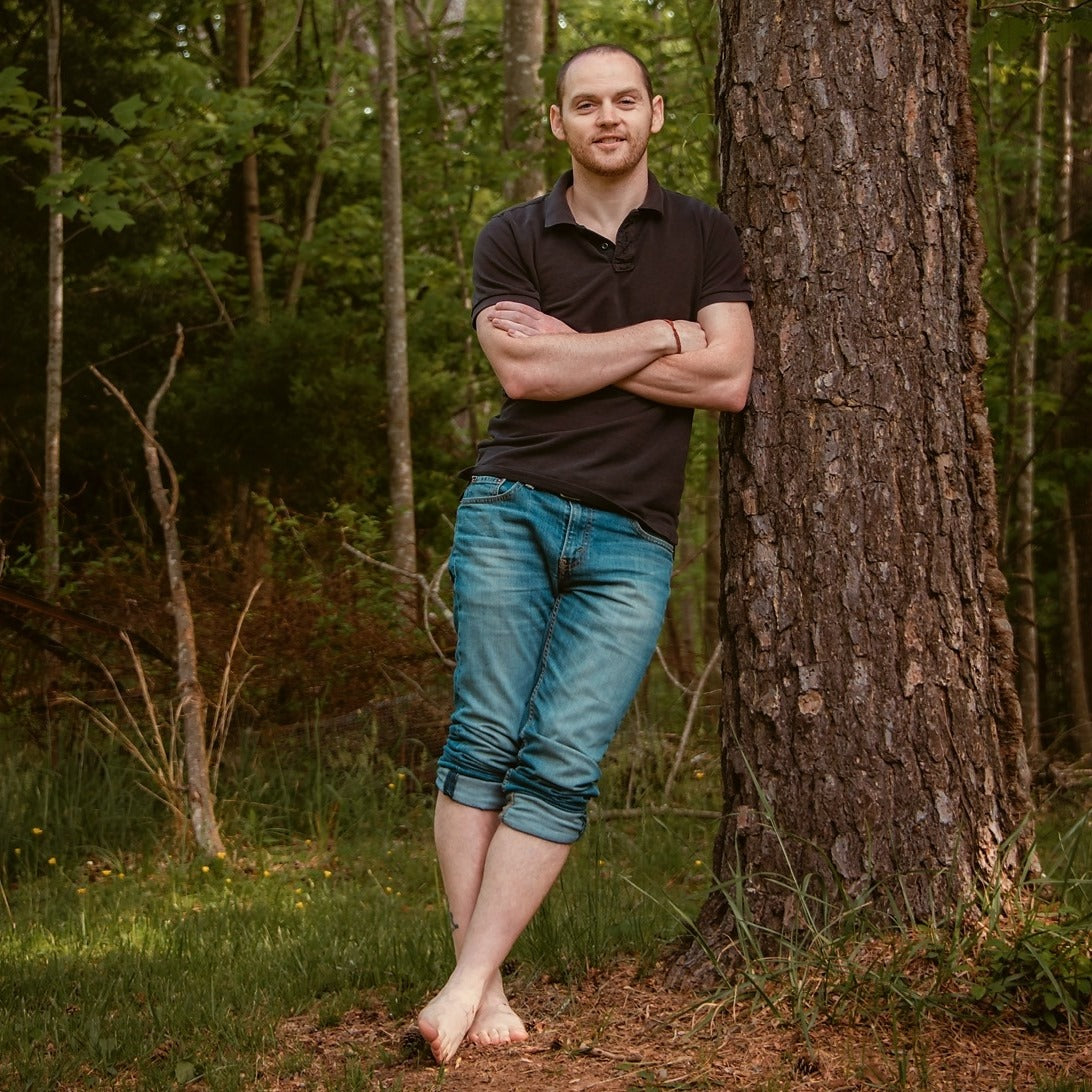 Barefoot Man Leaning On Tree